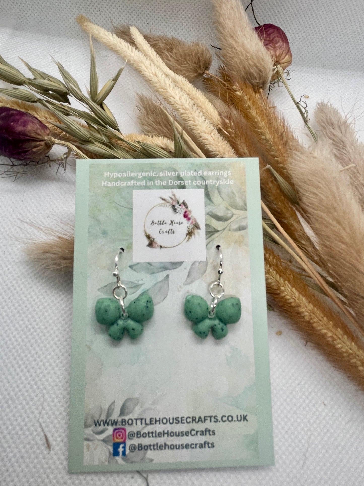 Sage green speckle mini winter bow earrings